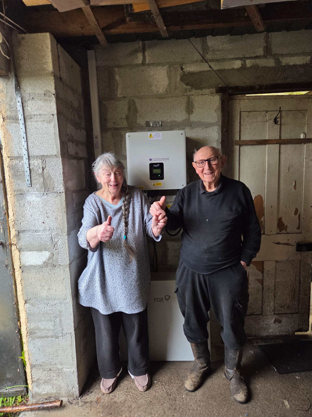 Customers smiling with their new FoxESS battery and inverter installation